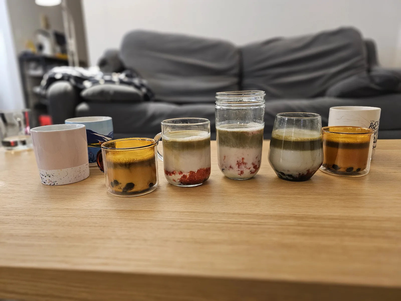 Lineup of homemade matcha lattes in assorted glassware